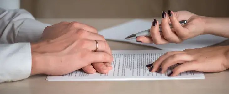 Married couple cooperating to sign a document in a collaborative divorce