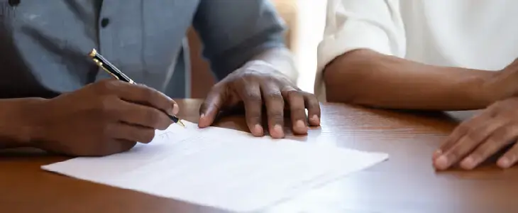 Engaged couple signing a prenuptial agreement before their marriage